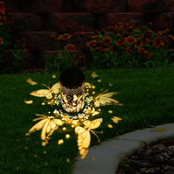 Outdoor Pluggable Or Hanging Iron Solar Butterfly Projector Lamp on grass in garden
