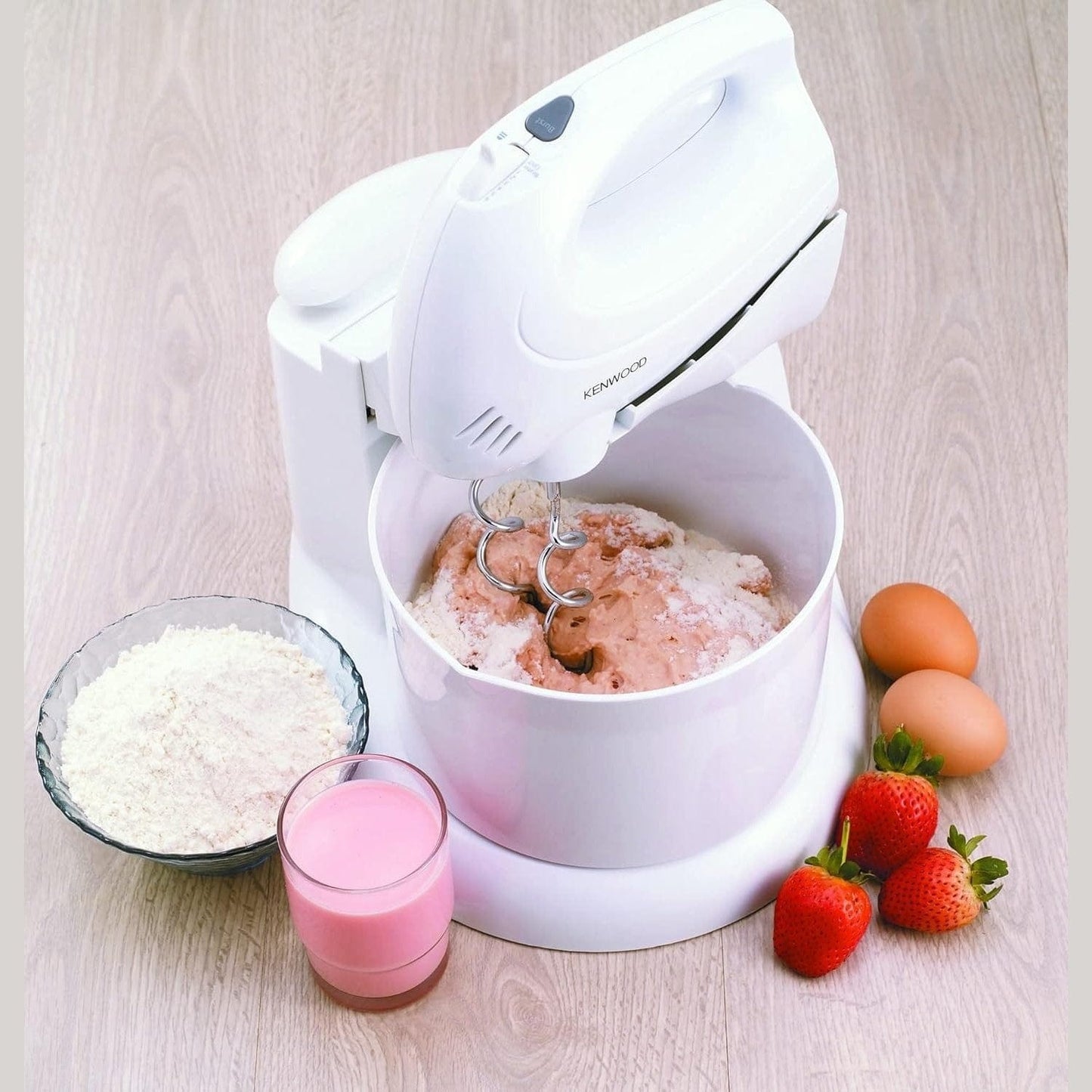 White Kenwood - Hand Mixer with Bowl (HM430) with ingredients on a wooden surface