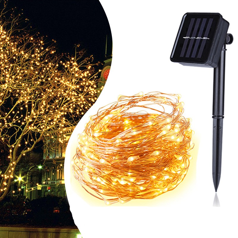 Solar-powered 100 200 LED Solar Copper Wire String Light
 with a coil of lights and solar panel on a reflective surface.