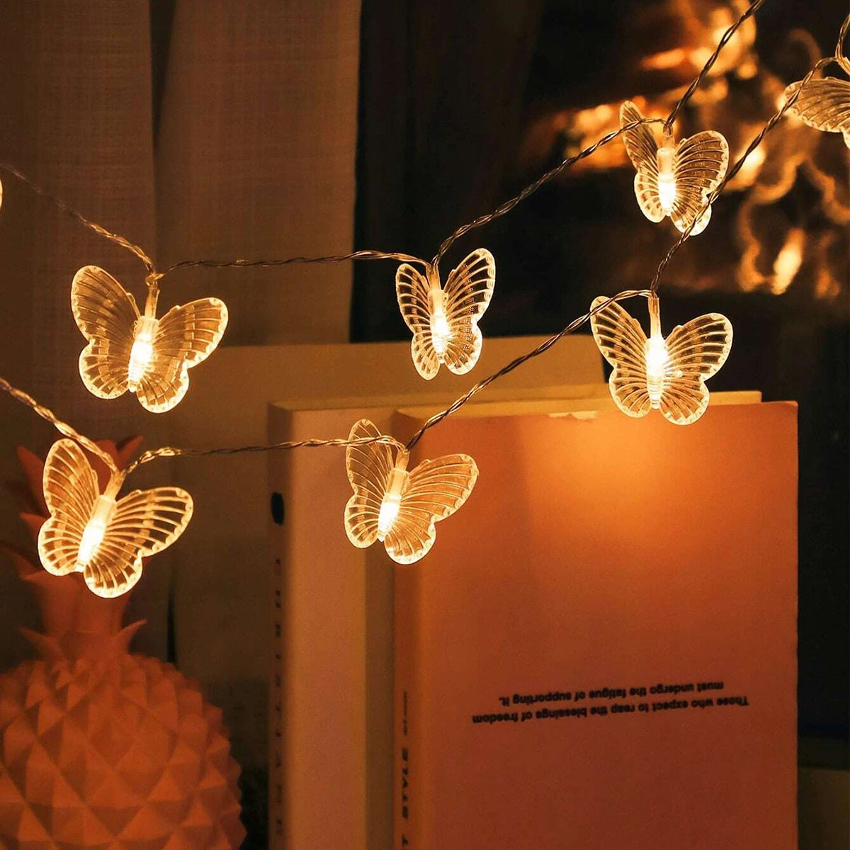 Butterfly string lights on a book with a warm glow
