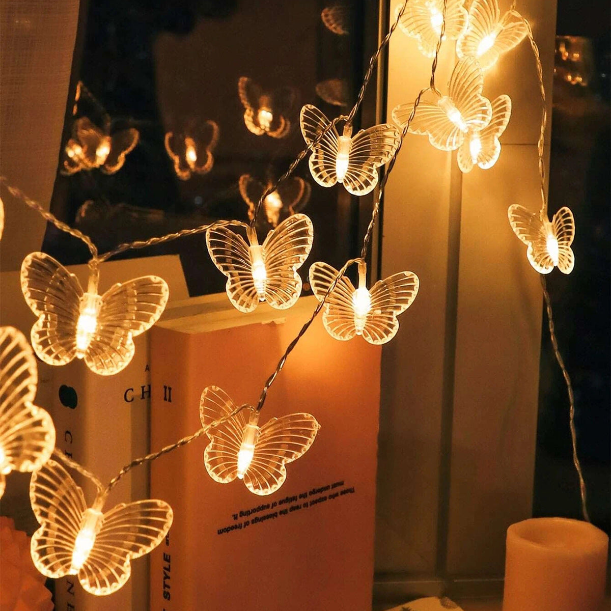 Butterfly string lights on a bookshelf with a warm glow