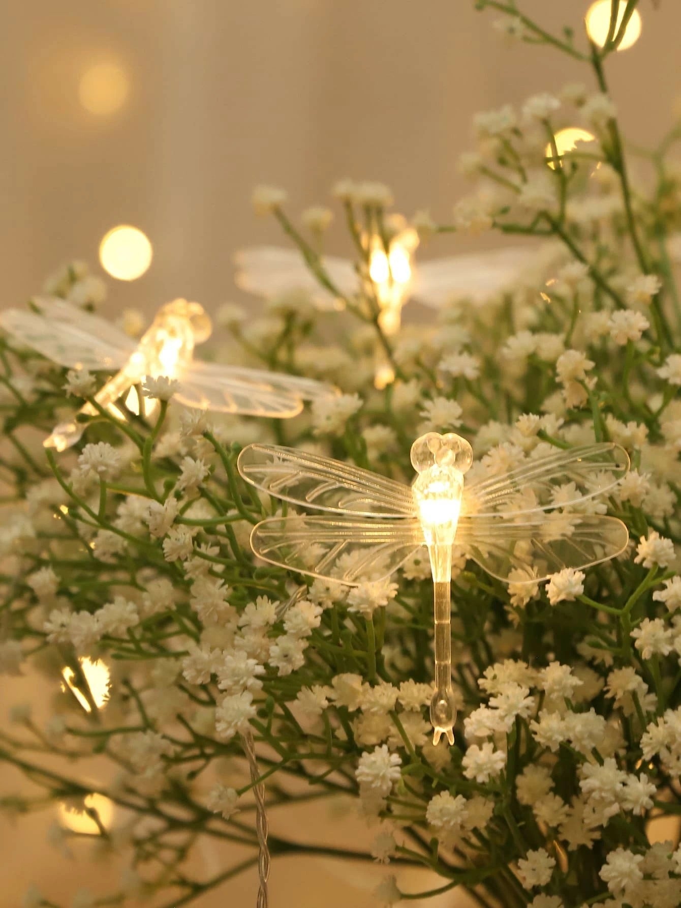Dragonfly-shaped string lights on a floral background