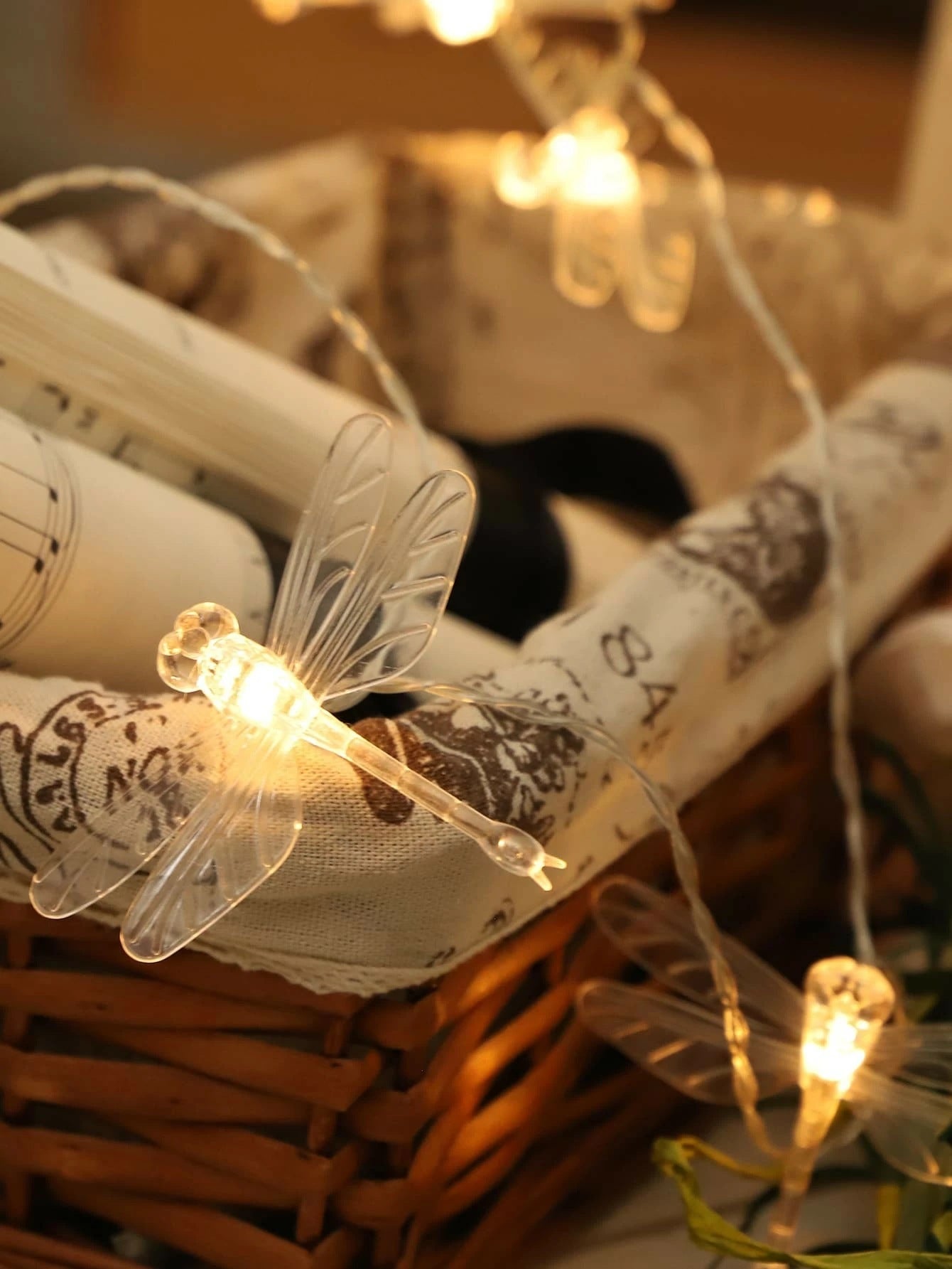 Decorative string lights with dragonfly designs on a textured surface.