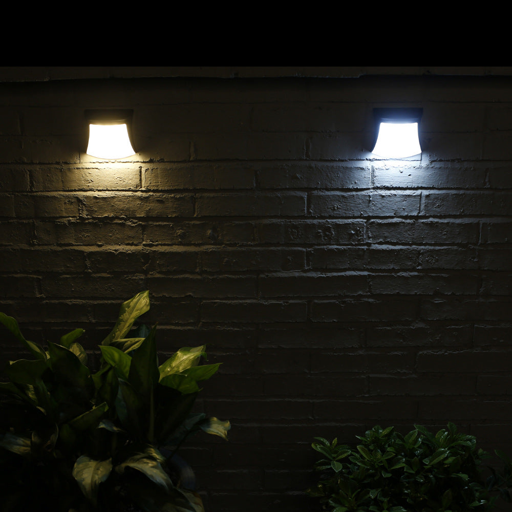 4pcs Solar Lamp Fence Wall Lamp Outdoor Waterproof Home Decoration Lighting Garden Wall Lamp. Two wall-mounted lights on a brick wall with plants in the foreground.