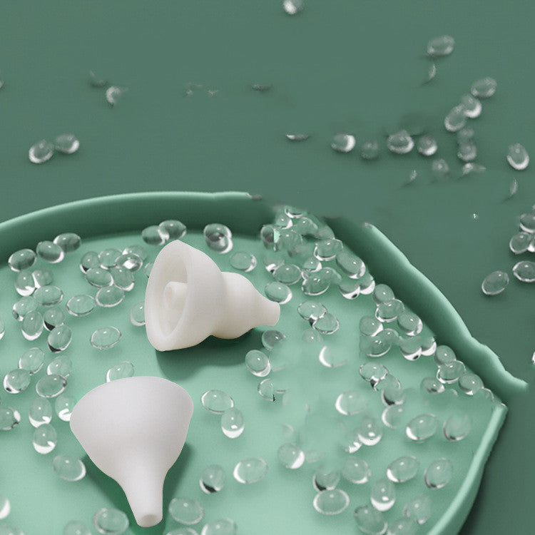 Two white silicone funnels of Baby Nasal Aspirator Electric Cleaning Household on a green surface with clear gel-like substance around them.