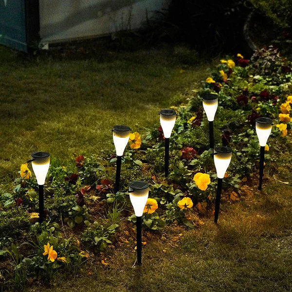 Solar Outdoor Water Decorative Street Light illuminating a garden with flowers at night.