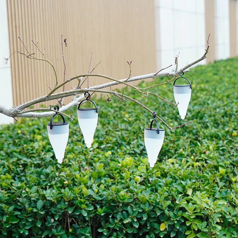 Solar Outdoor Water Decorative Street Light hanging from a branch with greenery in the background