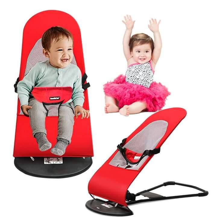 Red baby bouncer with two children using it on a white background