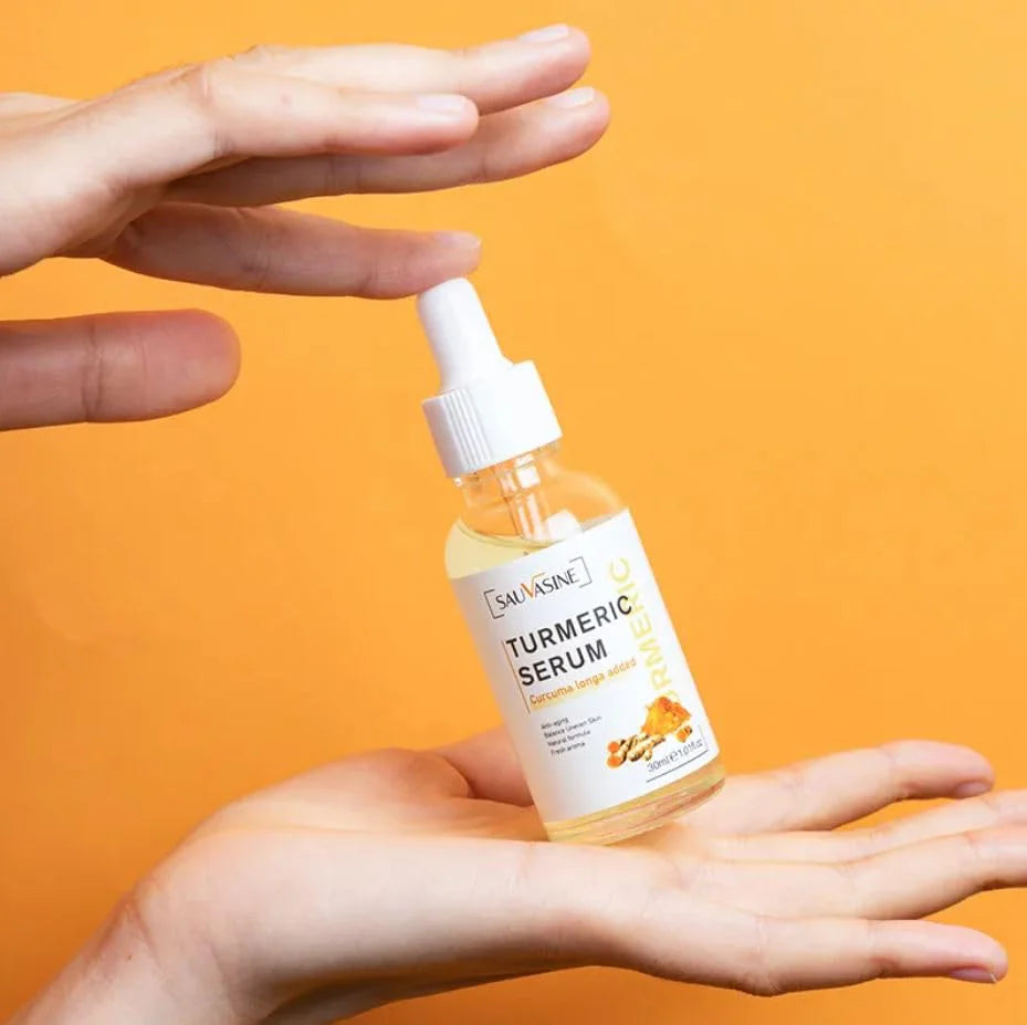 Beauty Lights Turmeric Serum (Original) bottle held in a hand against an orange background