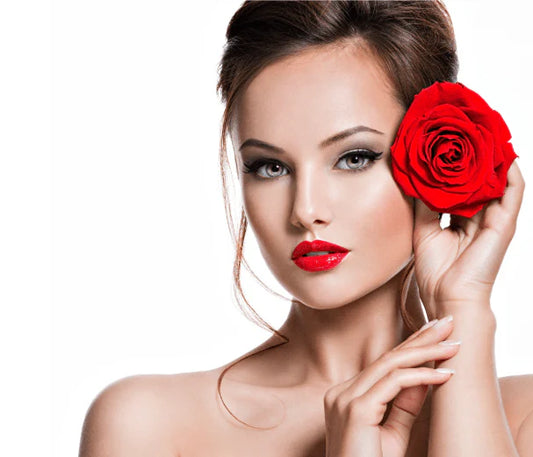 Woman with a red rose near her face on a white background