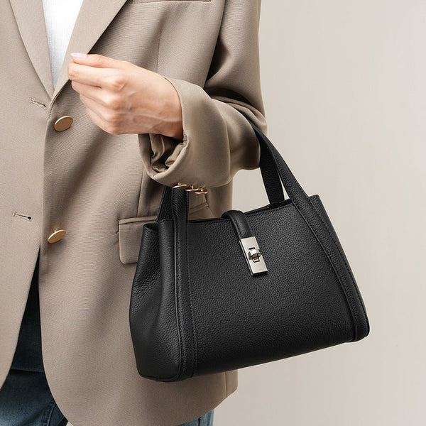 Person holding a black fashionable Korean style large capacity leather handbag wearing a beige blazer.