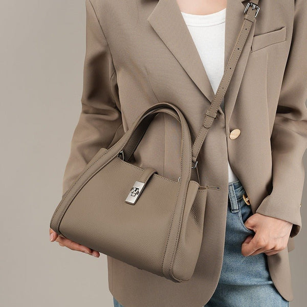 Person wearing a beige blazer holding a matching beige fashionable Korean style large capacity leather handbag against a neutral background