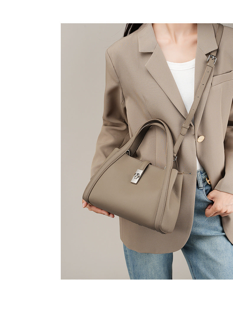 Person holding a beige handbag fashionable Korean style large capacity against a neutral background