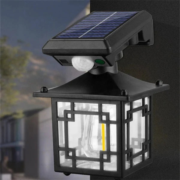 Outdoor Solar Sensor Light fixture with a clear glass cover on a blurred background